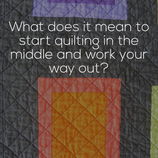 detail of modern quilt block in grey, orange, and purple with diagonal quilting lines